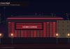 Kawhi Leonard Trade to Raptors Complete After NBA Cap Probe Hits Clippers Night exterior of a Toronto sports arena with red facade lights, a blank homecoming screen, city skyline, and empty plaza