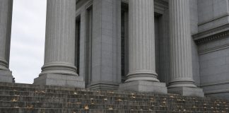 Jay-Z Accuser Recants Rape Allegation as Buzbee’s Lawyers Challenge Her Declaration Granite columns and stone steps of a courthouse on an overcast autumn day, with fallen leaves on the steps