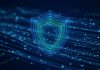 Google Gemini 4 Argon Launches First to Cyber Defenders Ahead of Wider Release A glowing layered blue and teal shield floating over streams of light particles on a dark blue background