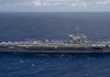 US Sends Third Aircraft Carrier Toward Iran as Another Tanker Is Hit in Hormuz Aircraft carrier USS Theodore Roosevelt under way at sea in a side view, with fighter jets parked on its flight deck, on open blue water