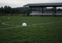 Cristiano Ronaldo Leaves Portugal Camp, Then Portugal Beat Denmark 4-2 Without Him A white football resting on the center circle of an empty training pitch, with orange cones and a covered team bench in the background on an overcast day