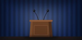 Katie Zacharia Out as White House Press Secretary After Five Days Illustration of an empty wooden podium with two microphones in front of a blue curtain