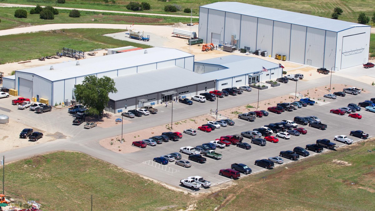 Aerial view of SpaceX's rocket development facility in McGregor, Texas, with industrial buildings and a parking lot